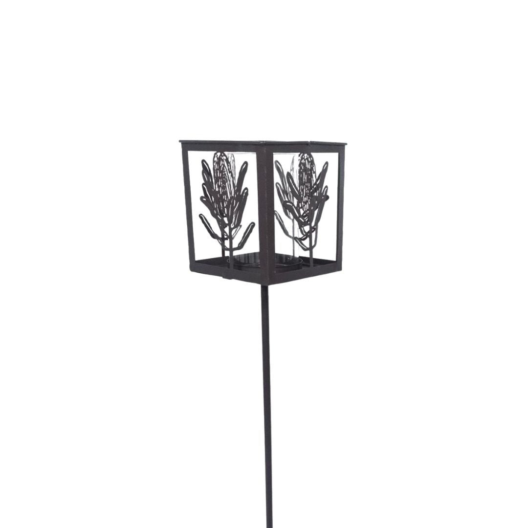 Black metal decorative stake with leaf design on a white background